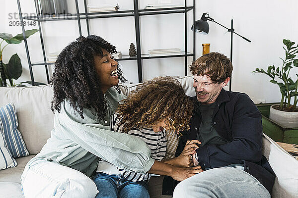 Happy family sitting on couch having fun at home