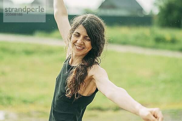 Carefree mature woman dancing with arms outstretched