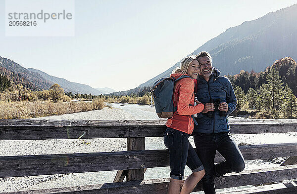 Happy mature couple standing in front of river