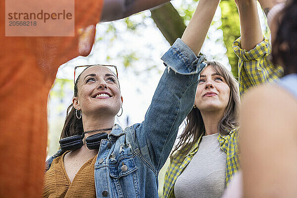 Smiling women with arms raised at park