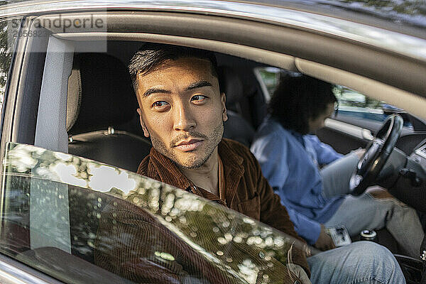 Thoughtful young man sitting with girlfriend in car