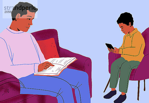 Father reading book on couch by son using tablet PC in front of blue background