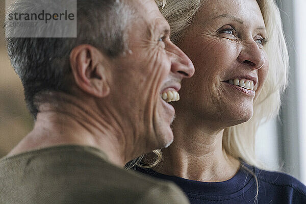 Cheerful retired senior couple looking away