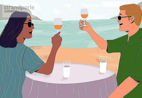 Couple enjoying drink at table on beach