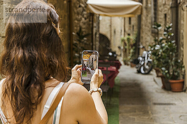 Woman photographing with mobile phone in downtown