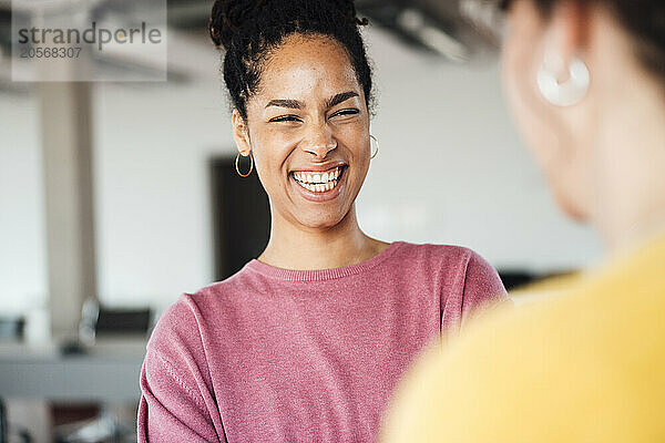 Cheerful businesswoman with colleague at office