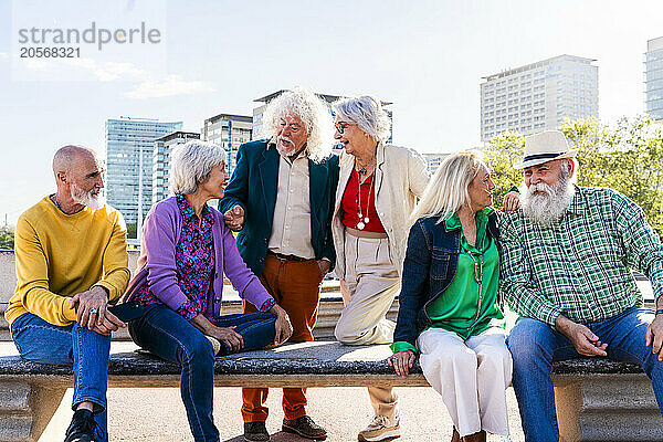 Retired friends talking to each other at bench