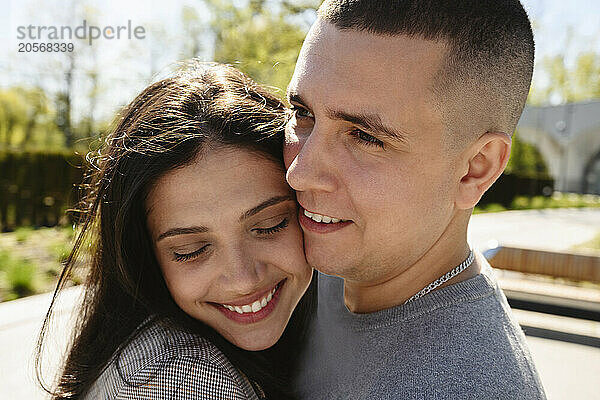 Smiling couple embracing at park