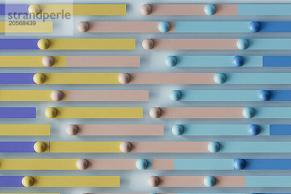 3D render of multi colored bars with spheres over blue background