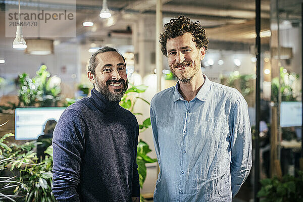 Smiling businessmen standing at cafe