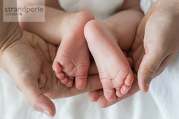 Hands of mother holding baby's foot