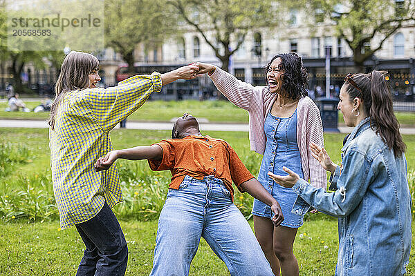 Carefree female friends dancing at park