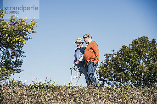 Smiling friends walking at field