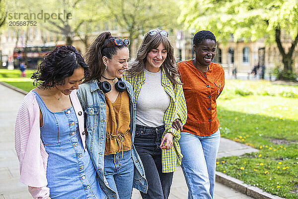 Cheerful multiracial female friends walking together