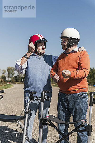 Senior friends wearing safety helmets at country road