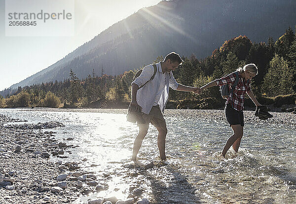 Heterosexual couple walking in river