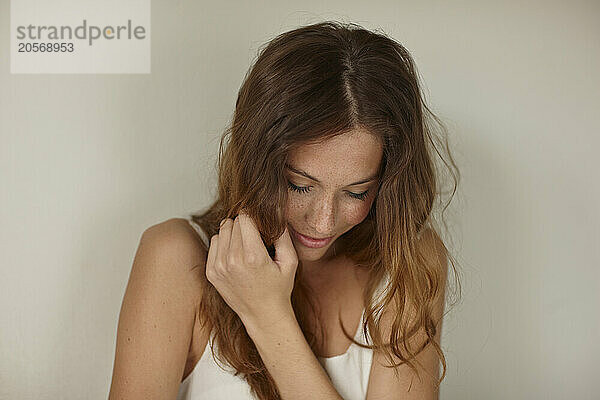 Young woman in front of wall