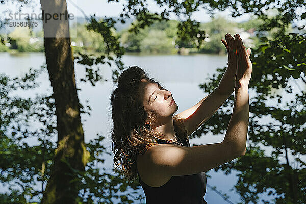 Woman shielding eyes by lake