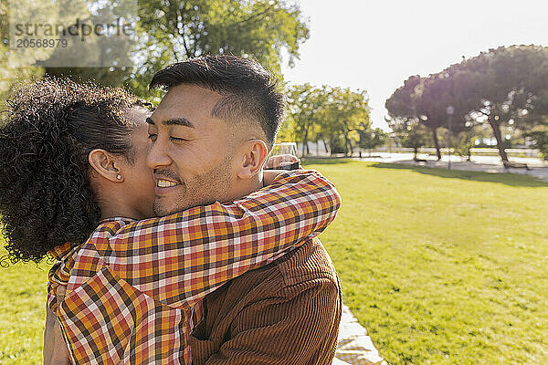 Young couple embracing at public park