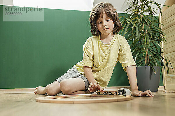 Boy playing with toy train set at home