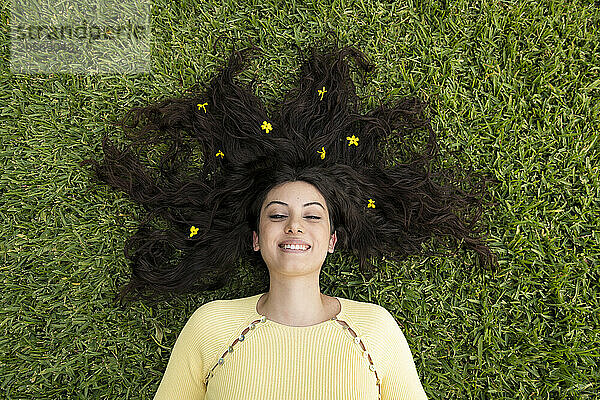 Beautiful woman lying on grass at garden