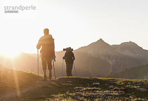 Mature couple with backpack and hiking pole walking on mountain of Tyrol in Austria