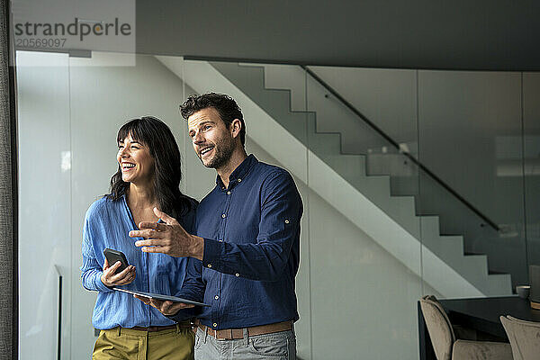 Happy businessman talking to businesswoman at home office