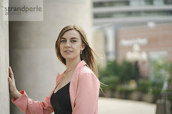 Confident blond hair woman with pink coat