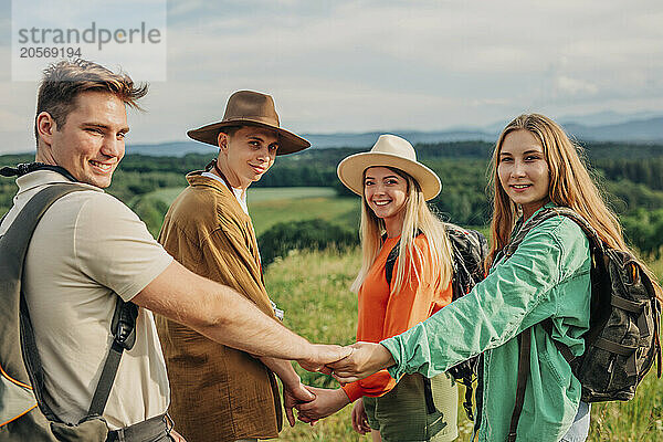 Smiling young couples holding hands on mountain