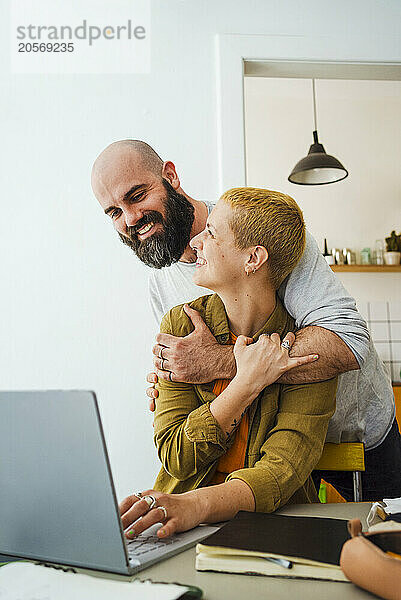 Happy couple embracing each other at home