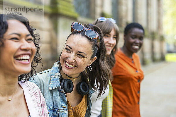 Cheerful multiracial women standing together