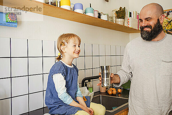 Father and daughter spending leisure time in kitchen at home