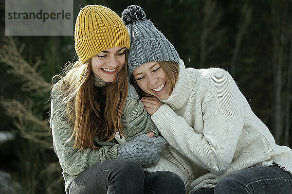 Happy friends in warm clothing enjoying vacation