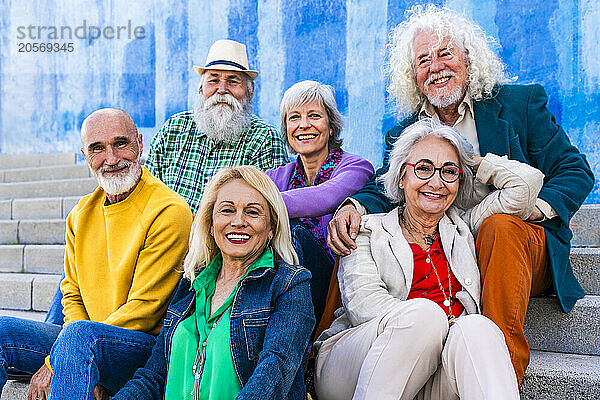 Happy friends sitting together on steps