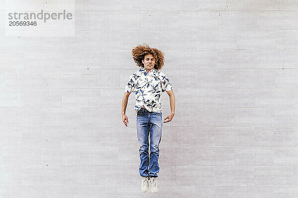 Man jumping in front of wall