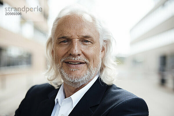 Smiling senior businessman at office park