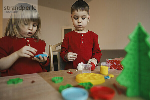 Siblings making Christmas decoration at home