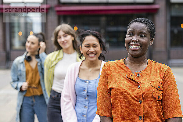 Smiling woman with short hair standing in front of friends