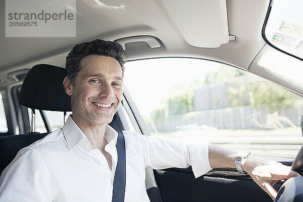 Smiling mature businessman driving car