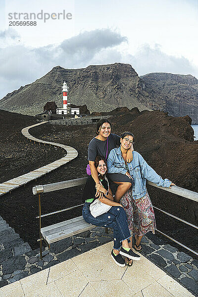 Group of young friends posing in front of Punta Teno Lighthouse in Spain