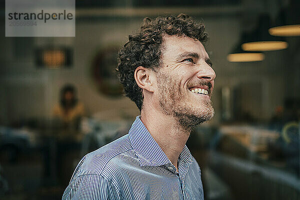 Carefree businessman standing in front of cafe