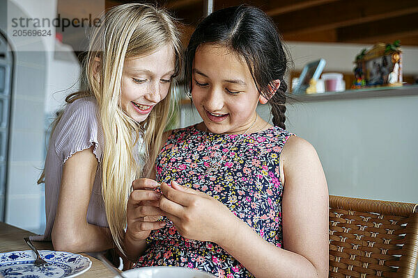 Smiling girls playing at dining table in home