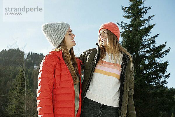 Cheerful friends in warm clothing enjoying vacation together