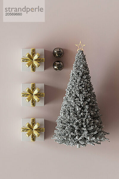 3D render of Christmas tree with gifts against pink background