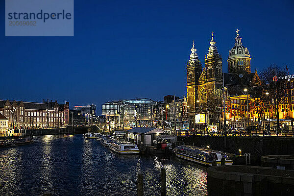 Basilica of St. Nicholas near Amstel river at blue hour