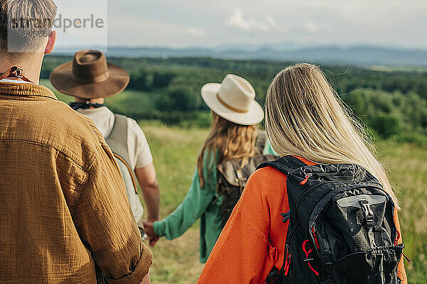 Young couples hiking with backpacks on mountain