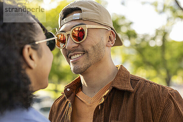 Smiling man wearing sunglasses with girlfriend