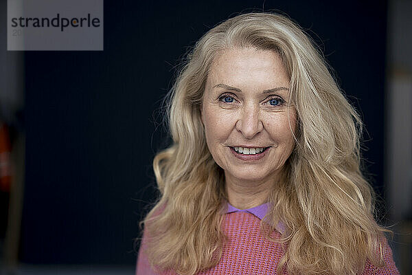 Smiling blond senior woman at home