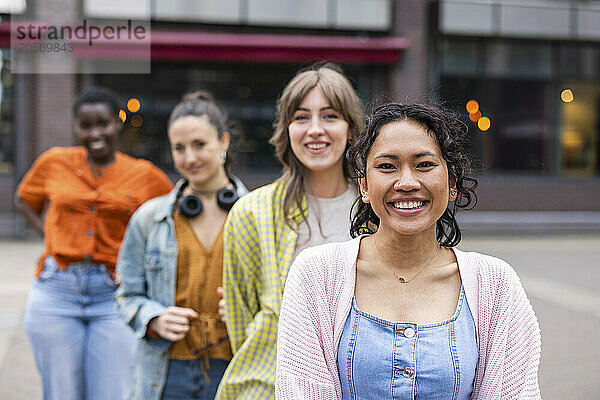 Smiling woman standing in front of friends