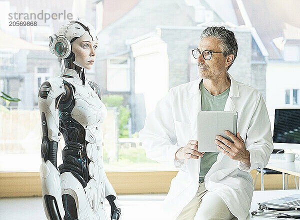 Mature engineer with tablet PC examining DNA in laboratory